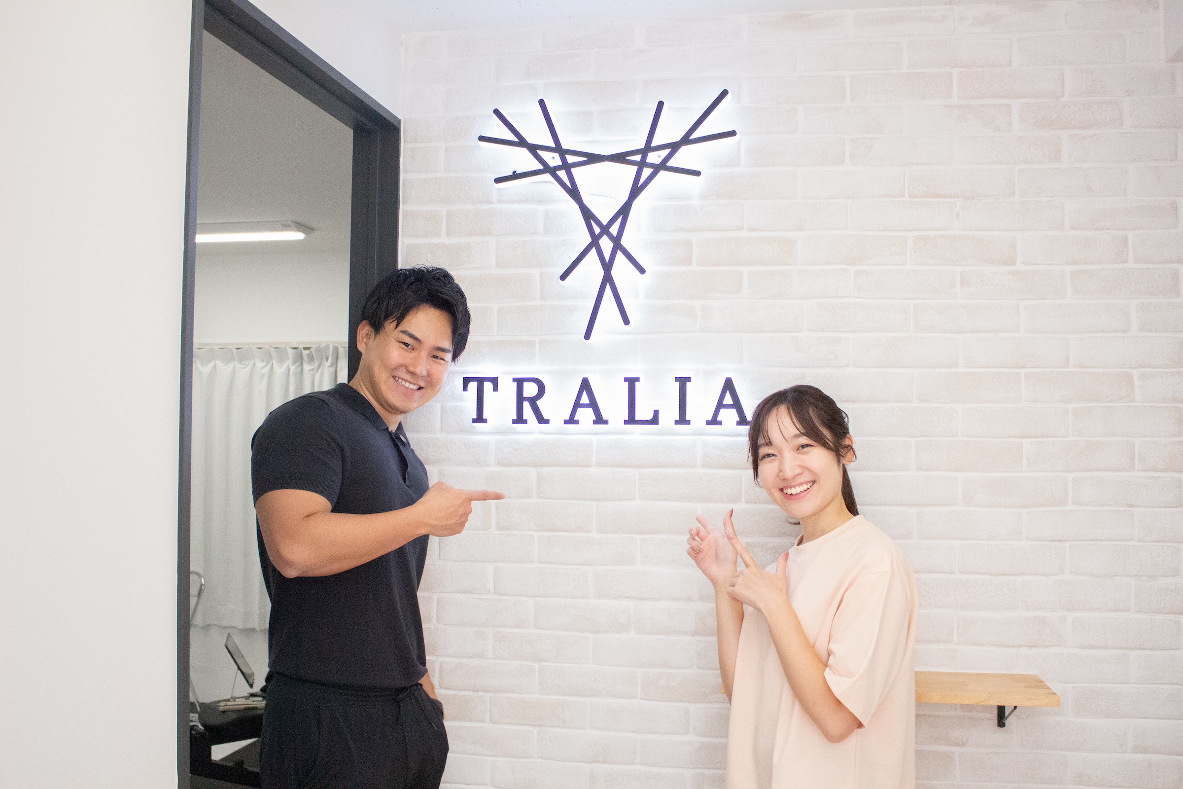 店舗の前で笑顔でポーズしている様子